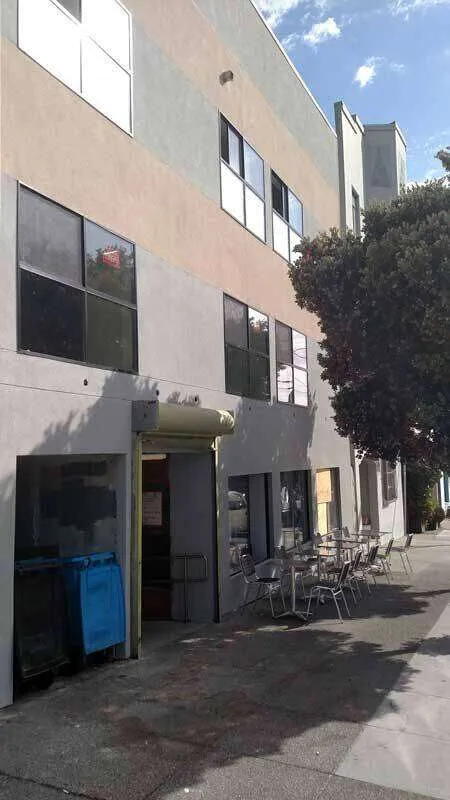 Three-story commercial building with stucco facade and large windows in San Francisco.