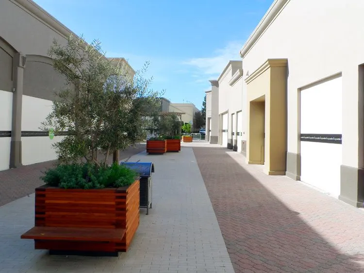 Commercial walkway with EIFS-finished buildings and planters at Napa Town Center.