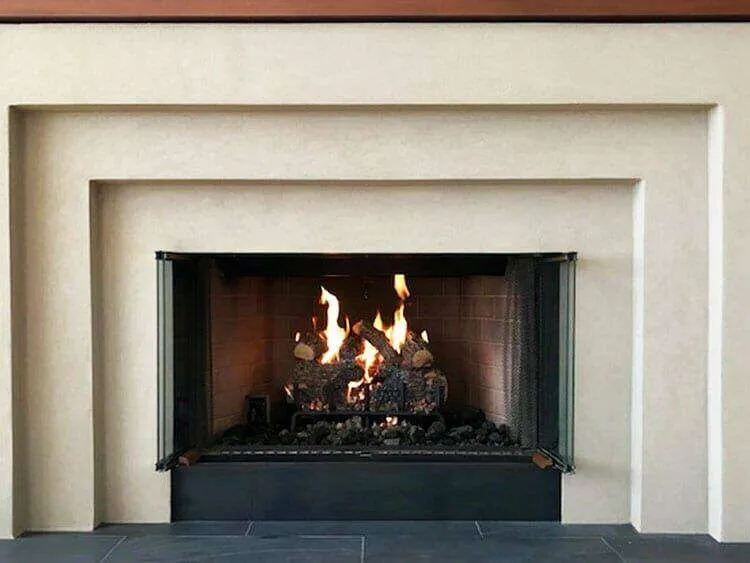 Modern fireplace with Lymestone acrylic finish and lit fire, showcasing clean lines and geometric design.