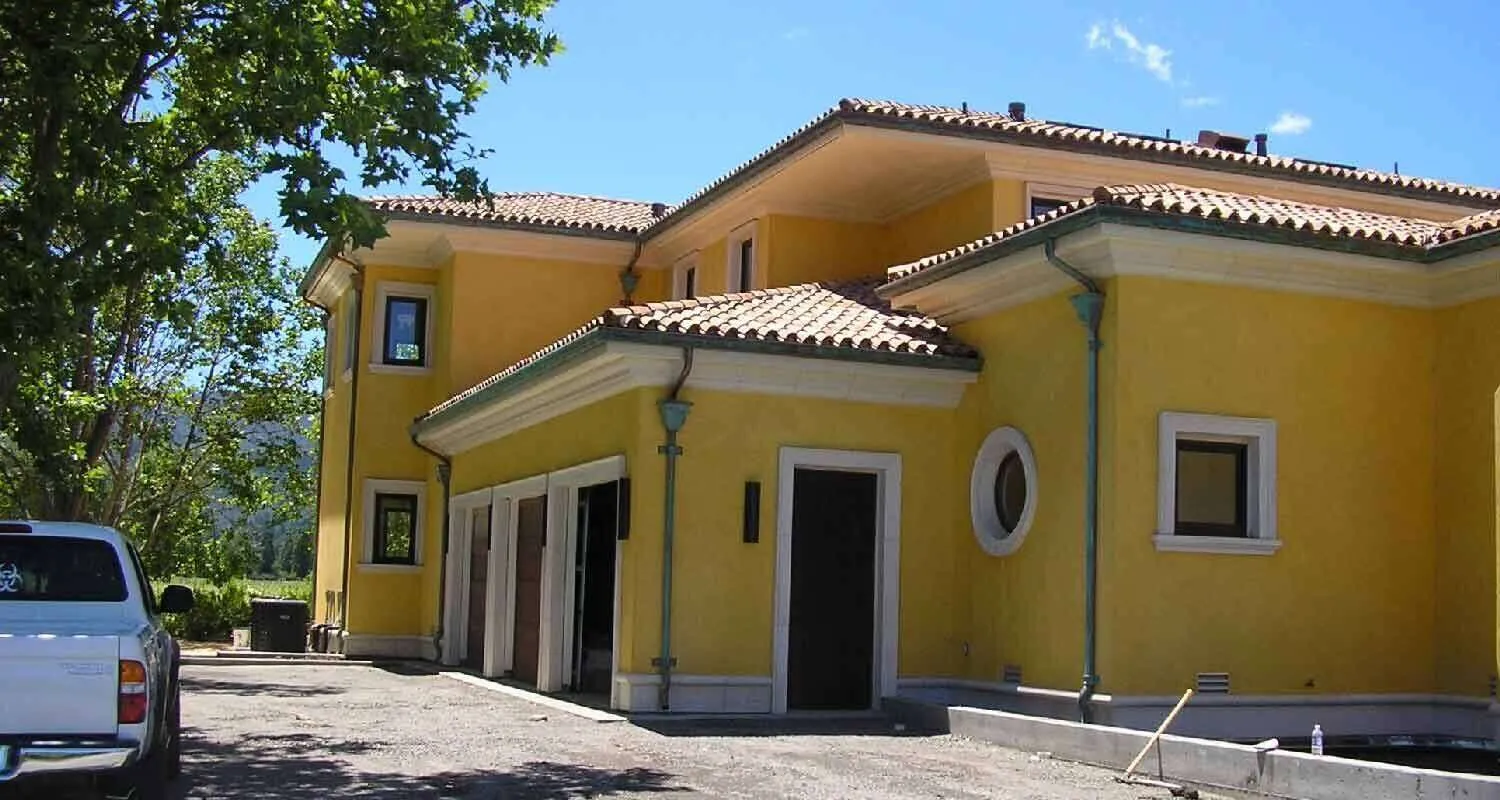 Yellow stucco Mediterranean-style home with tiled roof and driveway in Sonoma Valley.