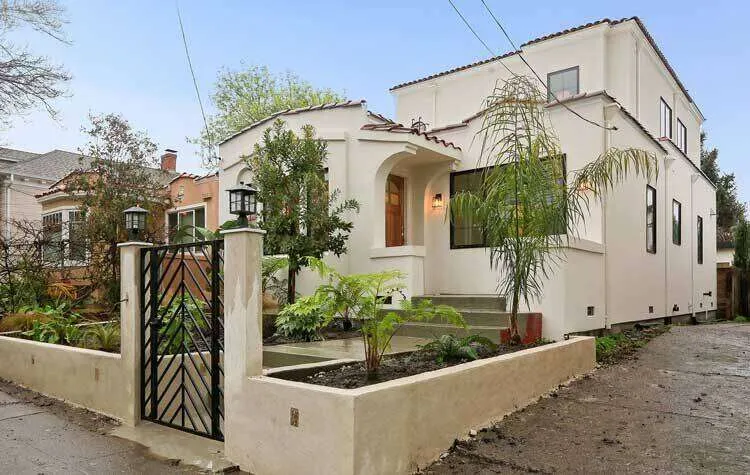 Two-story stucco home with gated entrance and landscaped yard in Oakland.