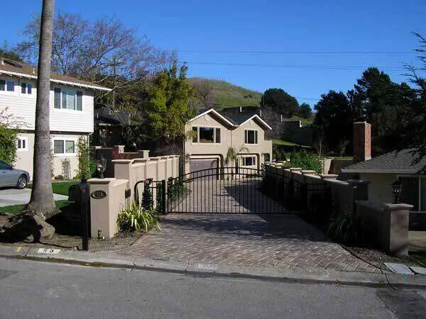 Stucco home in Greenbrae with a gated driveway and landscaped surroundings.